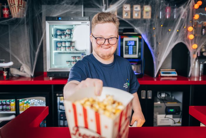 Student serving popcorn at the cinema.